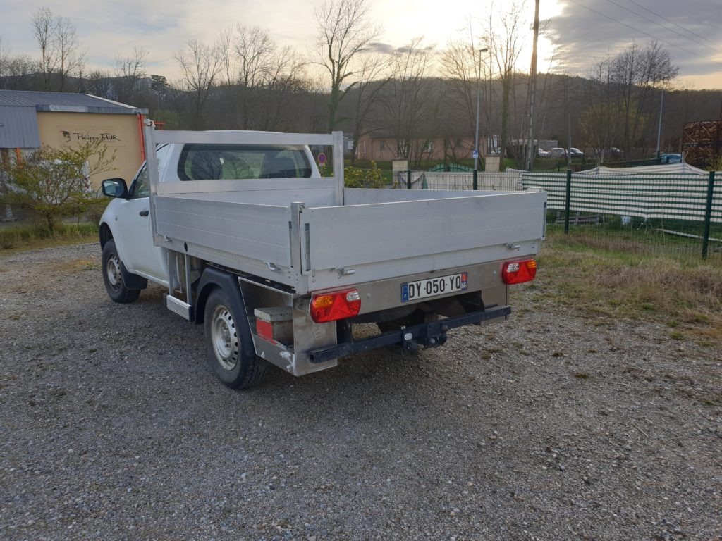 Benne en aluminium et ridelles d’un pick-up — vue arrière en extérieur.