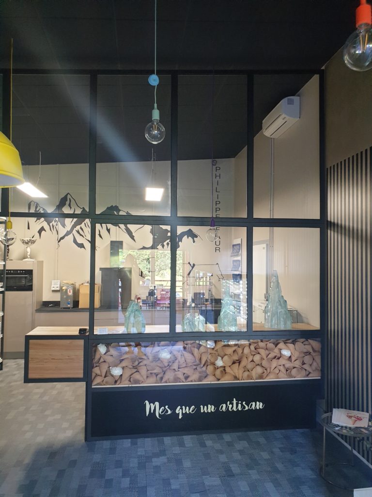 Verrière métallique et comptoir — vue d’ensemble dans la boutique.