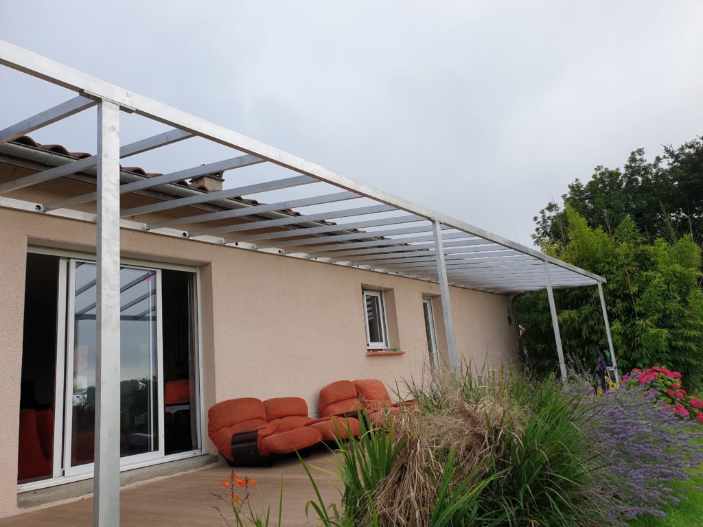 Pergola adossée à une maison — détail des traverses et des poteaux.