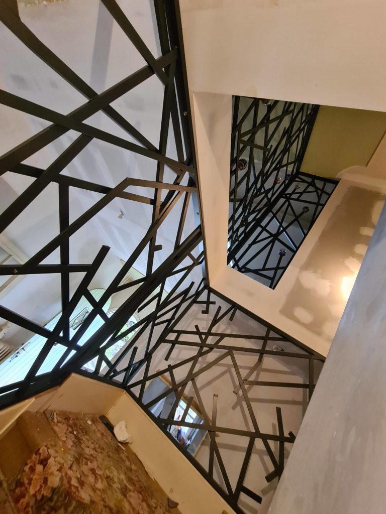 Garde-corps intérieur à motifs géométriques — vue du palier.