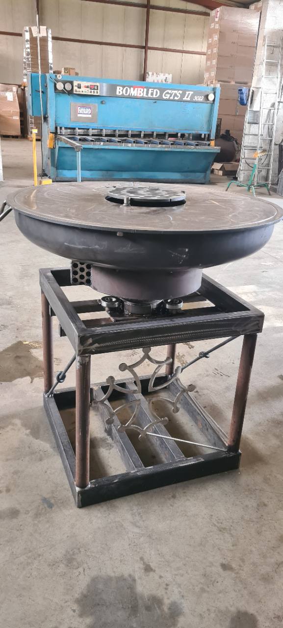 Brasero circulaire sur un support métallique décoratif.