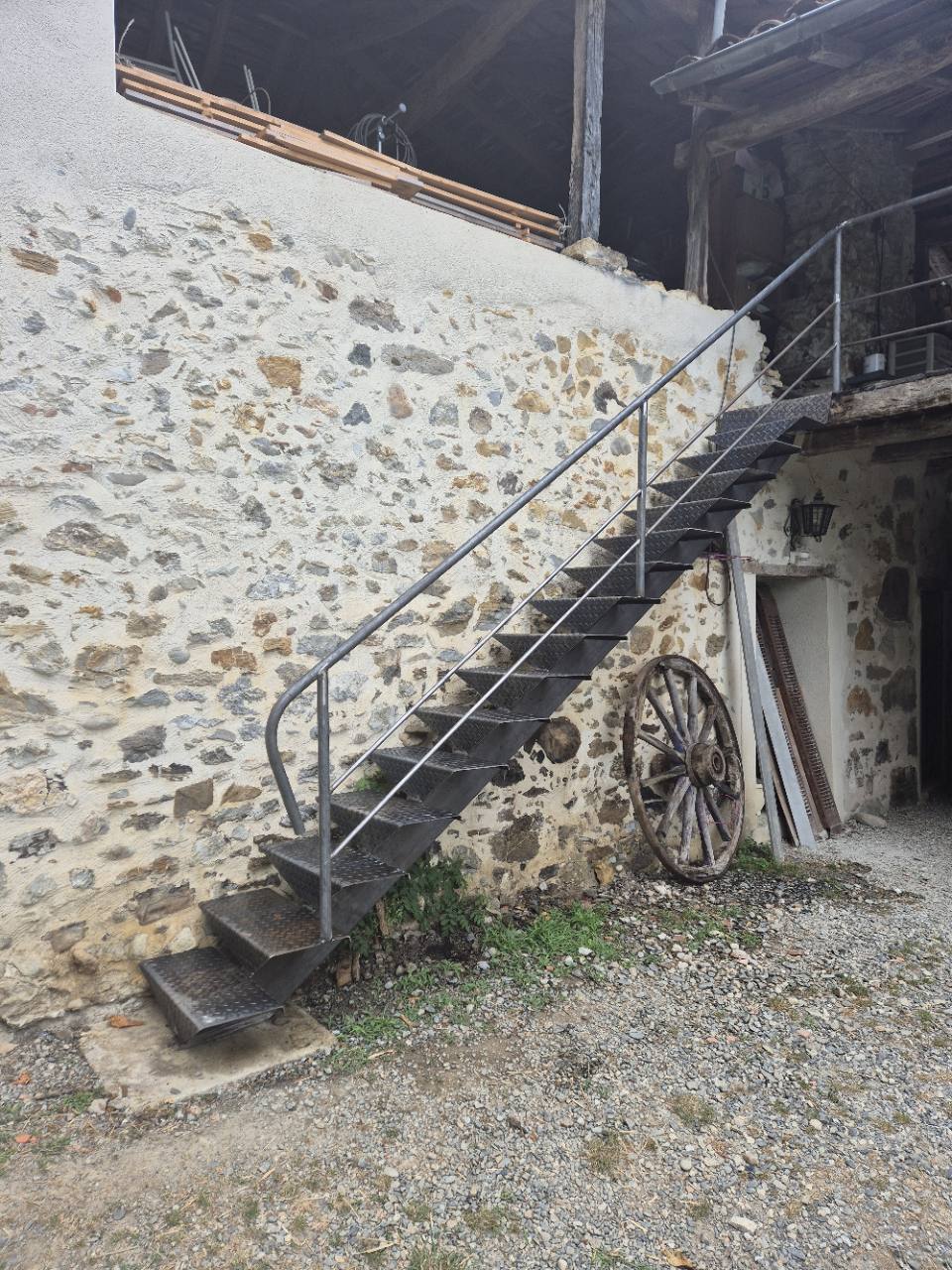 Escalier métallique extérieur avec marches en tôle et garde-corps.