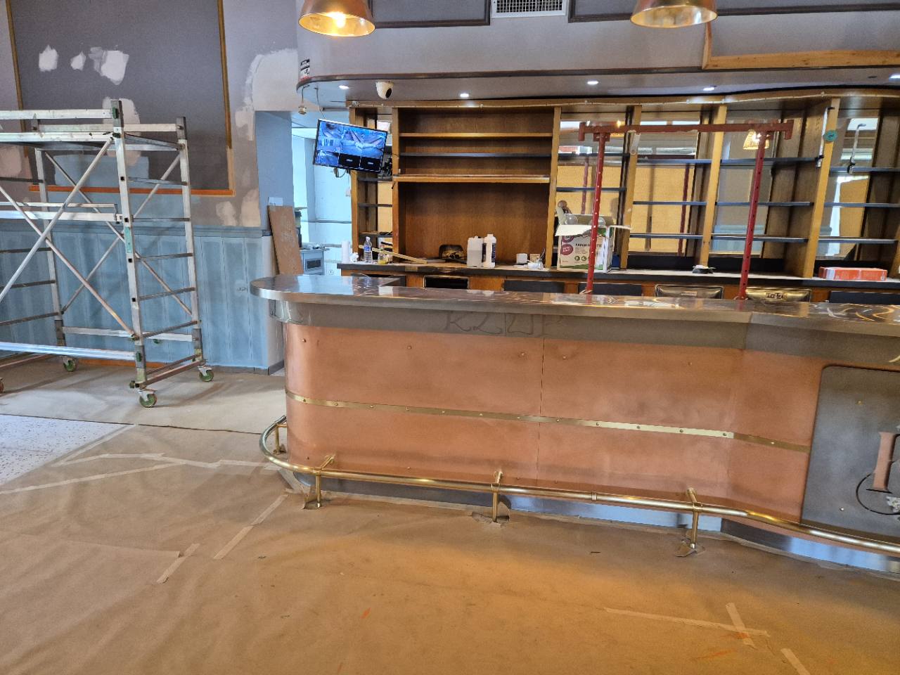 Comptoir du Klub à Saint-Girons après reconstruction, avec habillage en cuivre et repose-pieds.
