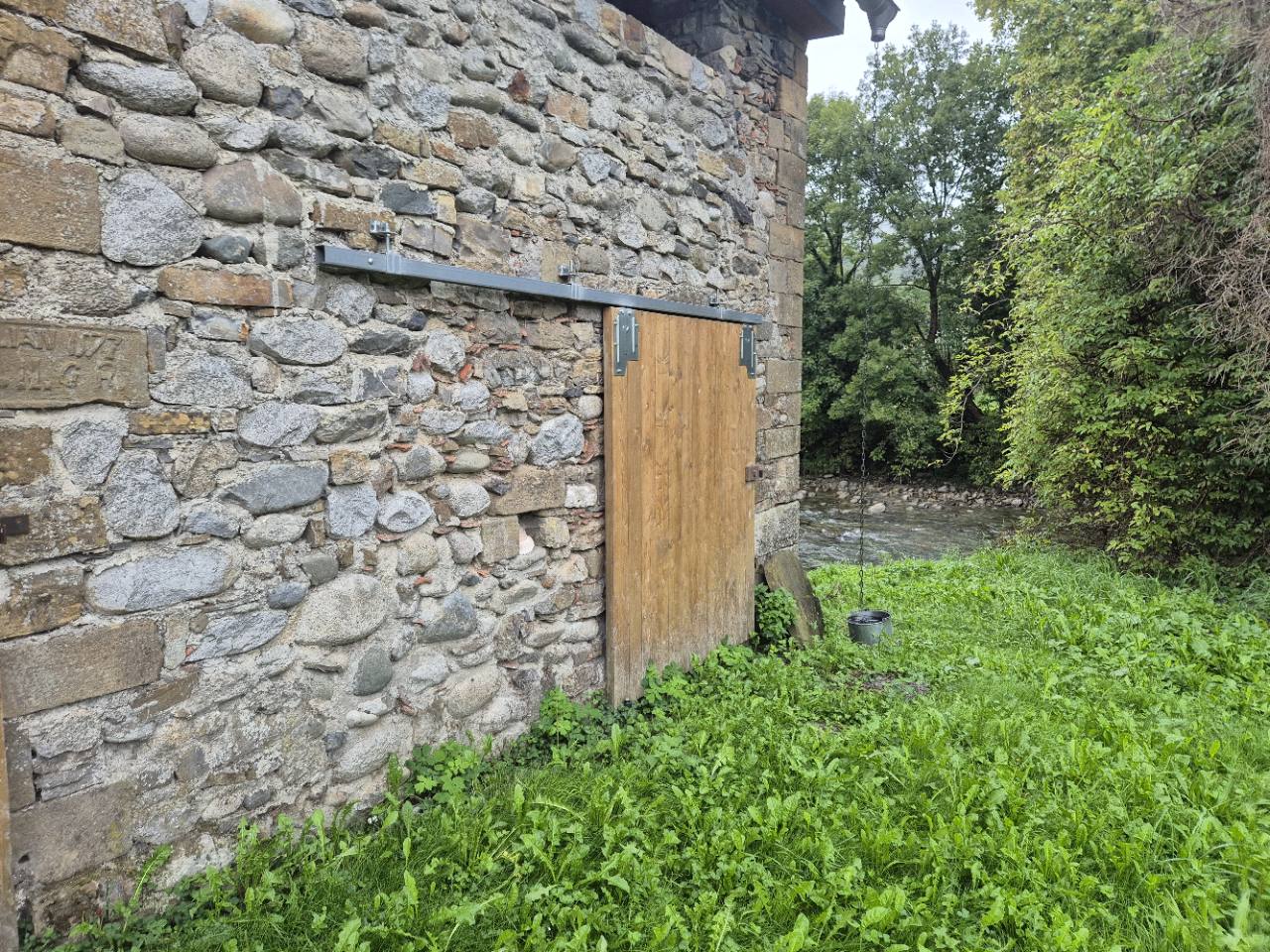 Porte coulissante en bois équipée d’un rail et de ferrures métalliques.