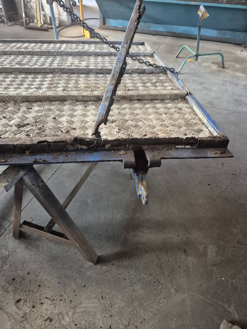 Rampe métallique de chargement présentant des éléments corrodés avant réparation.
