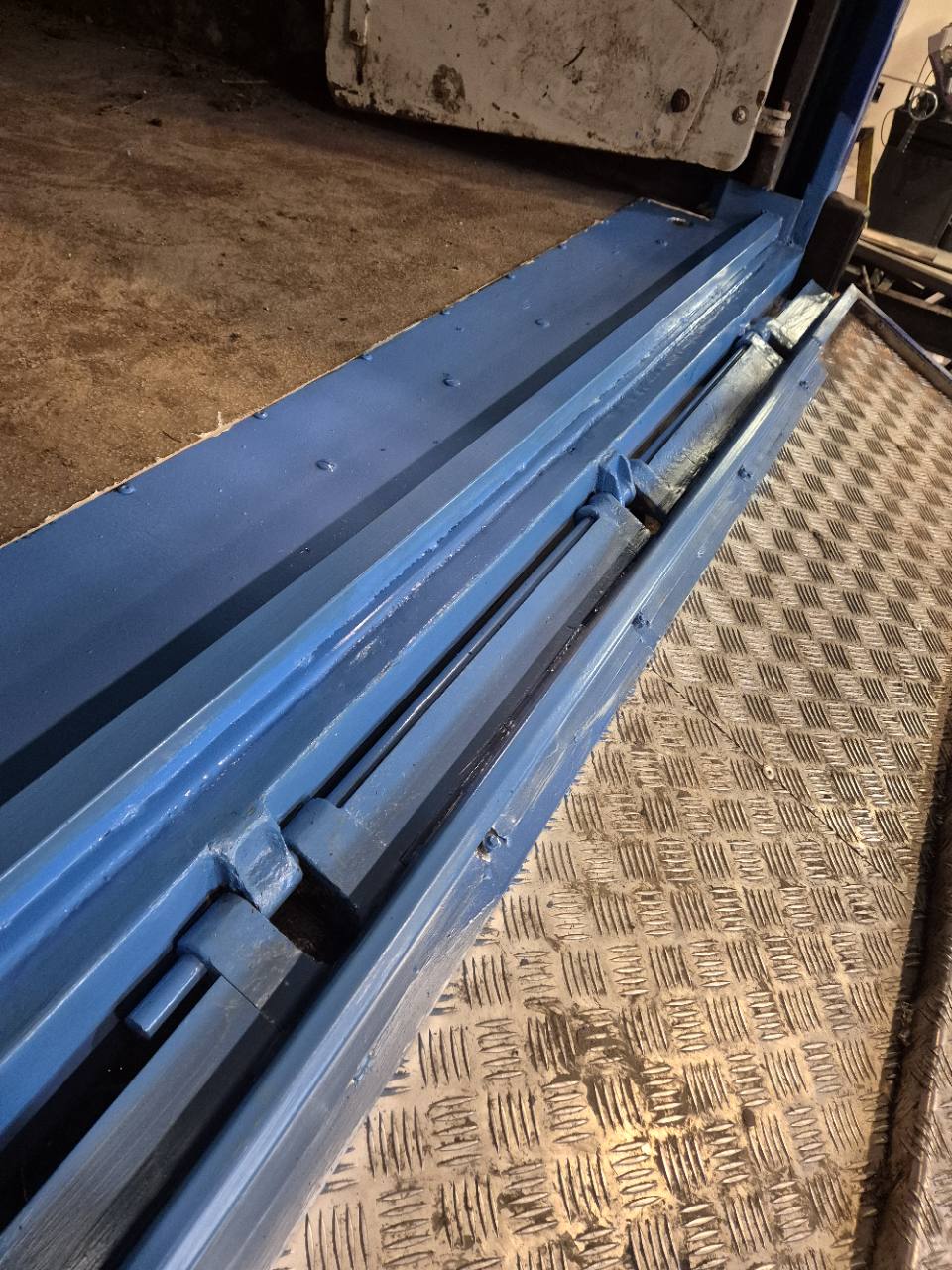 Détail de la charnière et des assemblages d’une rampe métallique après travaux.