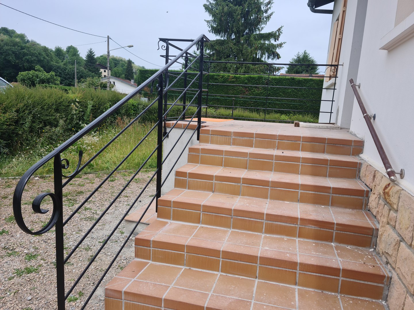 Main courante et garde-corps d’escalier extérieur — vue depuis le bas.