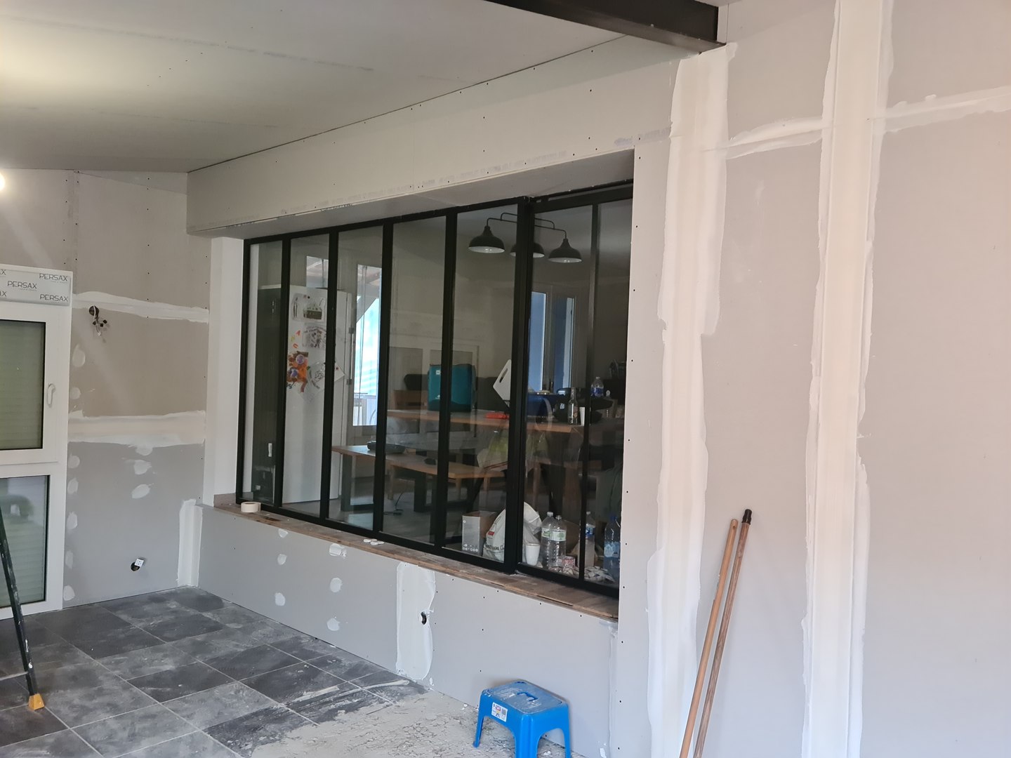 Verrière intérieure à montants métalliques — vue d’ensemble pendant le chantier.