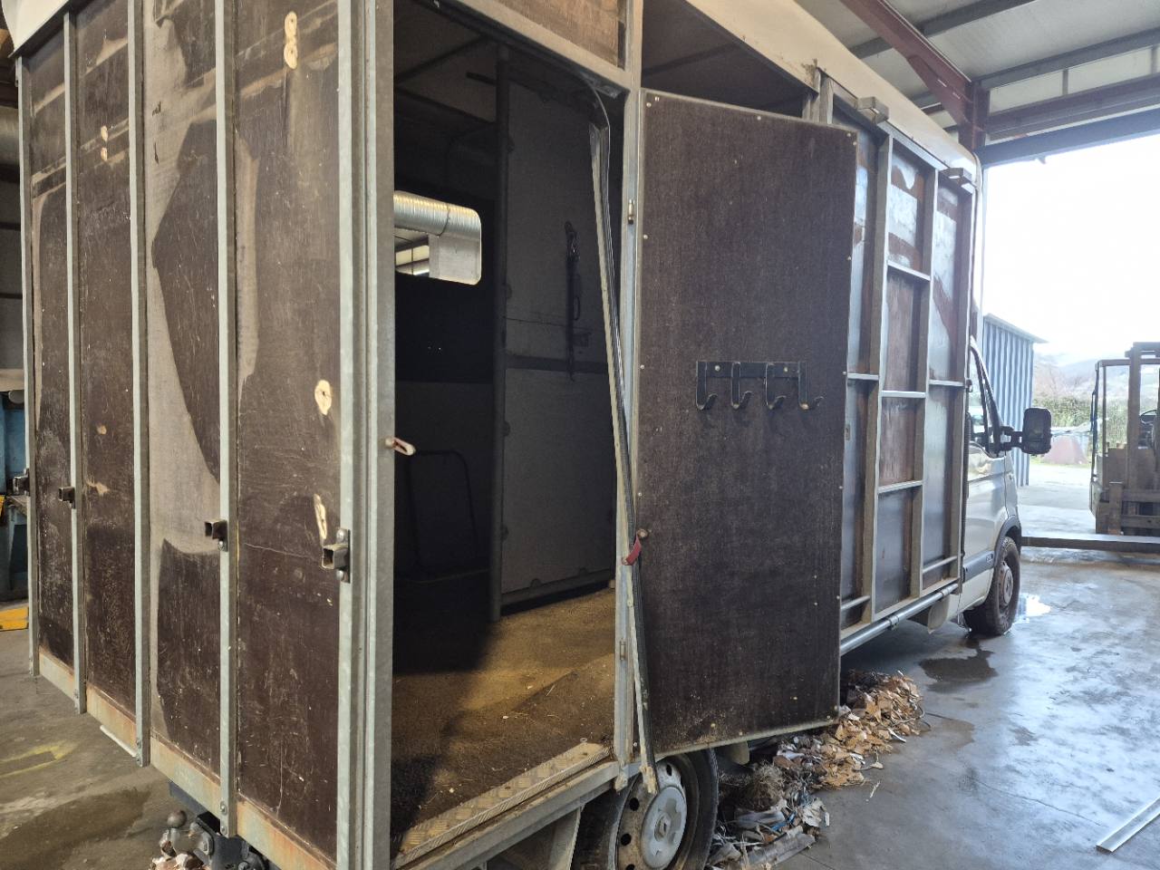 Ancienne caisse d’un utilitaire de transport, avec vue sur les panneaux et les portes.